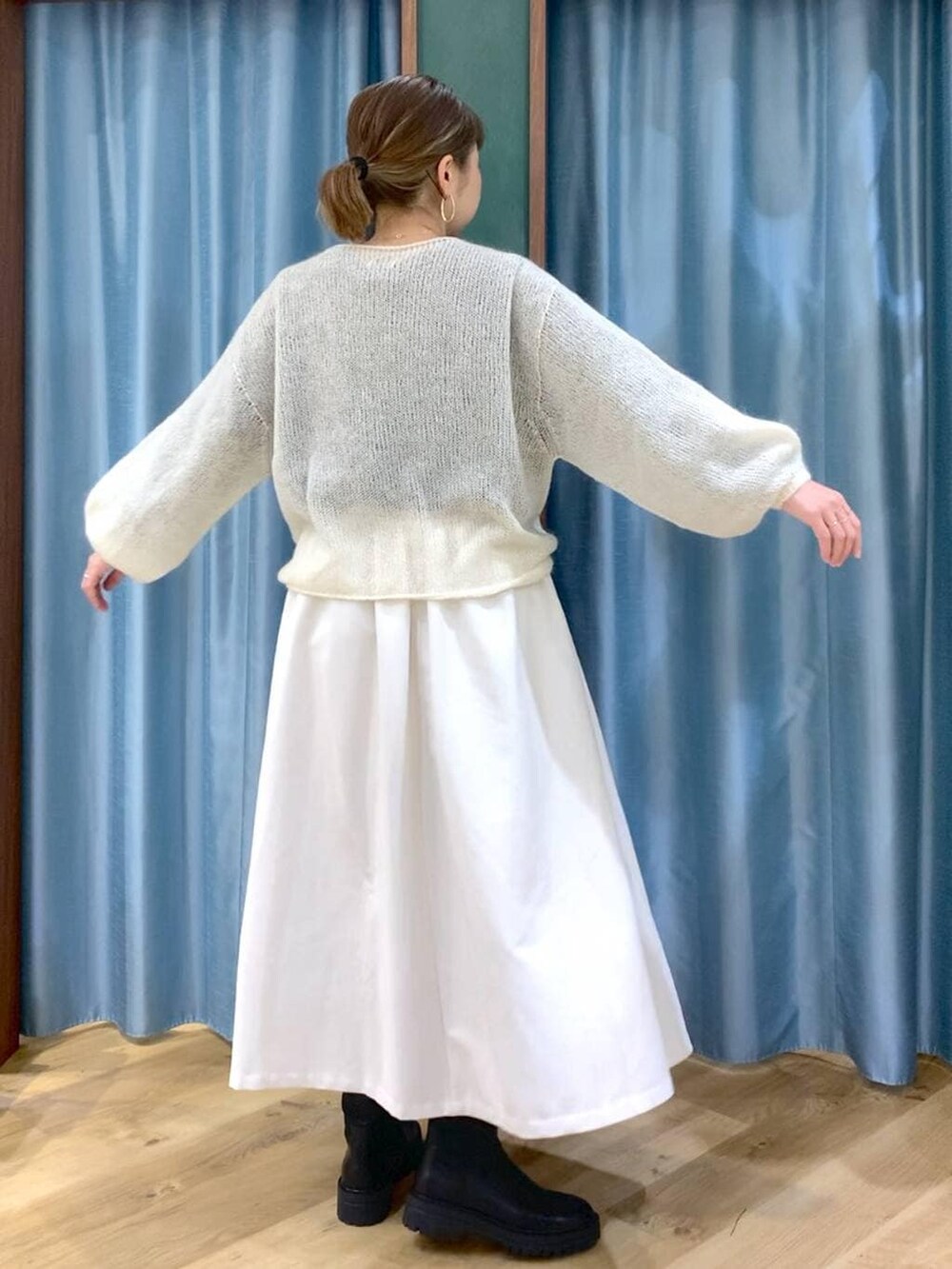 ブラック系のブーツ、ホワイト系のスカート、ホワイト系のニット/セーターを着用したレディースの冬コーディネートの6枚目の写真