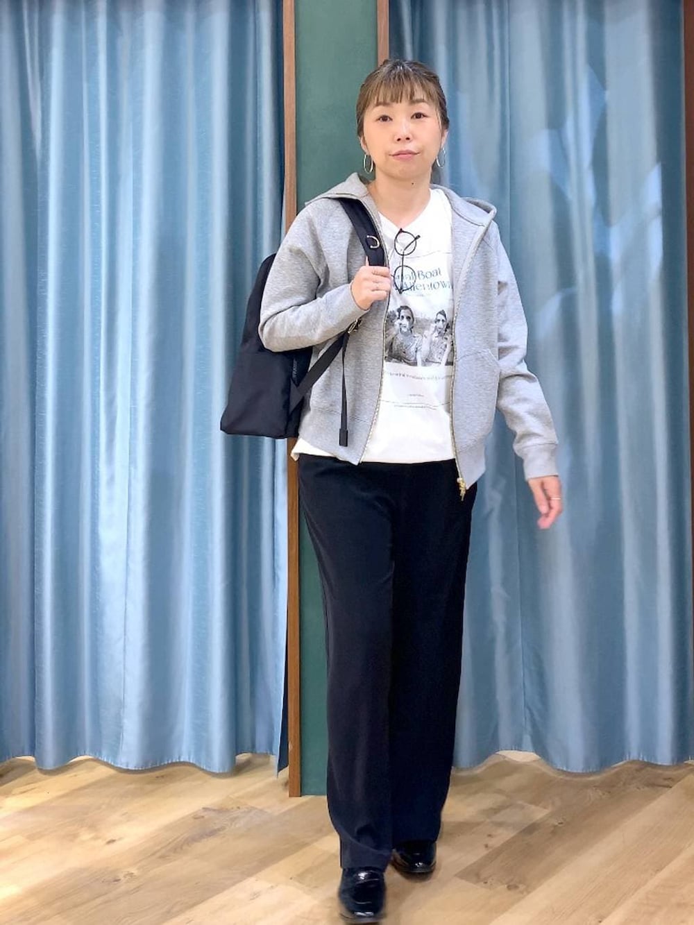 ブラック系のバックパック/リュック、ブラック系のスラックス、グレー系のパーカーを着用したレディースの春コーディネートの3枚目の写真