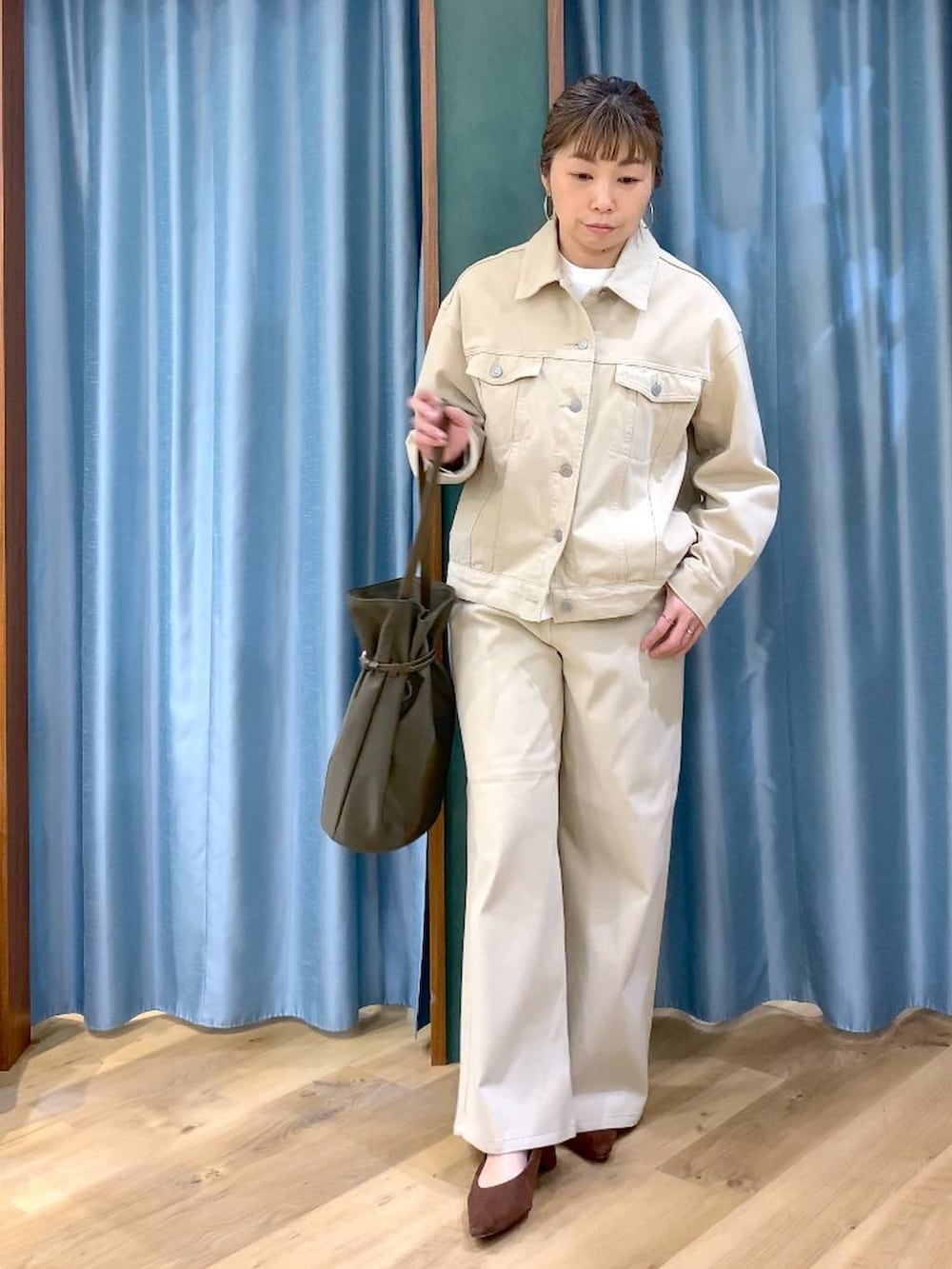 ブラウン系のパンプス、ベージュ系のデニムパンツ、ベージュ系のデニムジャケットを着用したレディースの春コーディネートの3枚目の写真