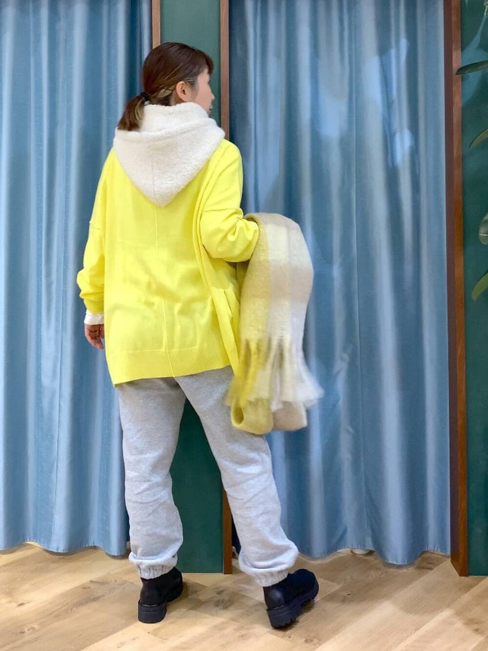 ブラック系のブーツ、ホワイト系のTシャツ/カットソー、イエロー系のニット/セーターを着用したレディースの秋コーディネートの5枚目の写真