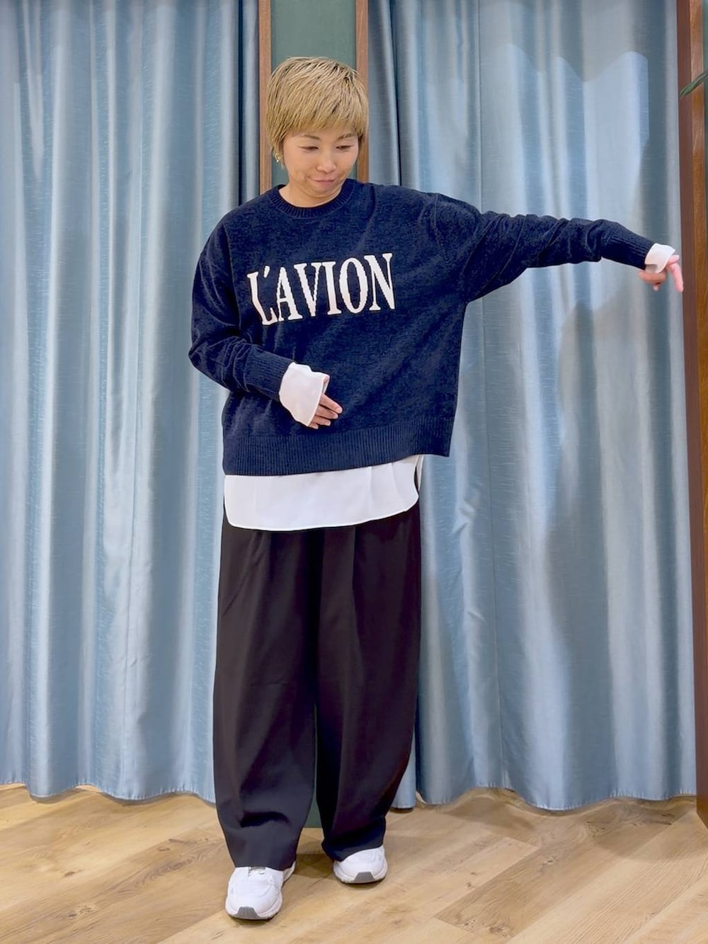 ブルー系のニット/セーター、ホワイト系のTシャツ/カットソー、ブラック系のその他パンツを着用したレディースの秋コーディネートの4枚目の写真