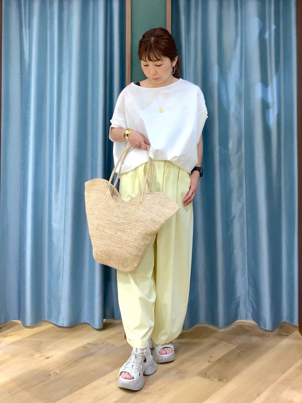 ホワイト系のTシャツ/カットソー、イエロー系のその他パンツ、グレー系のサンダルを着用したレディースの春コーディネートの2枚目の写真