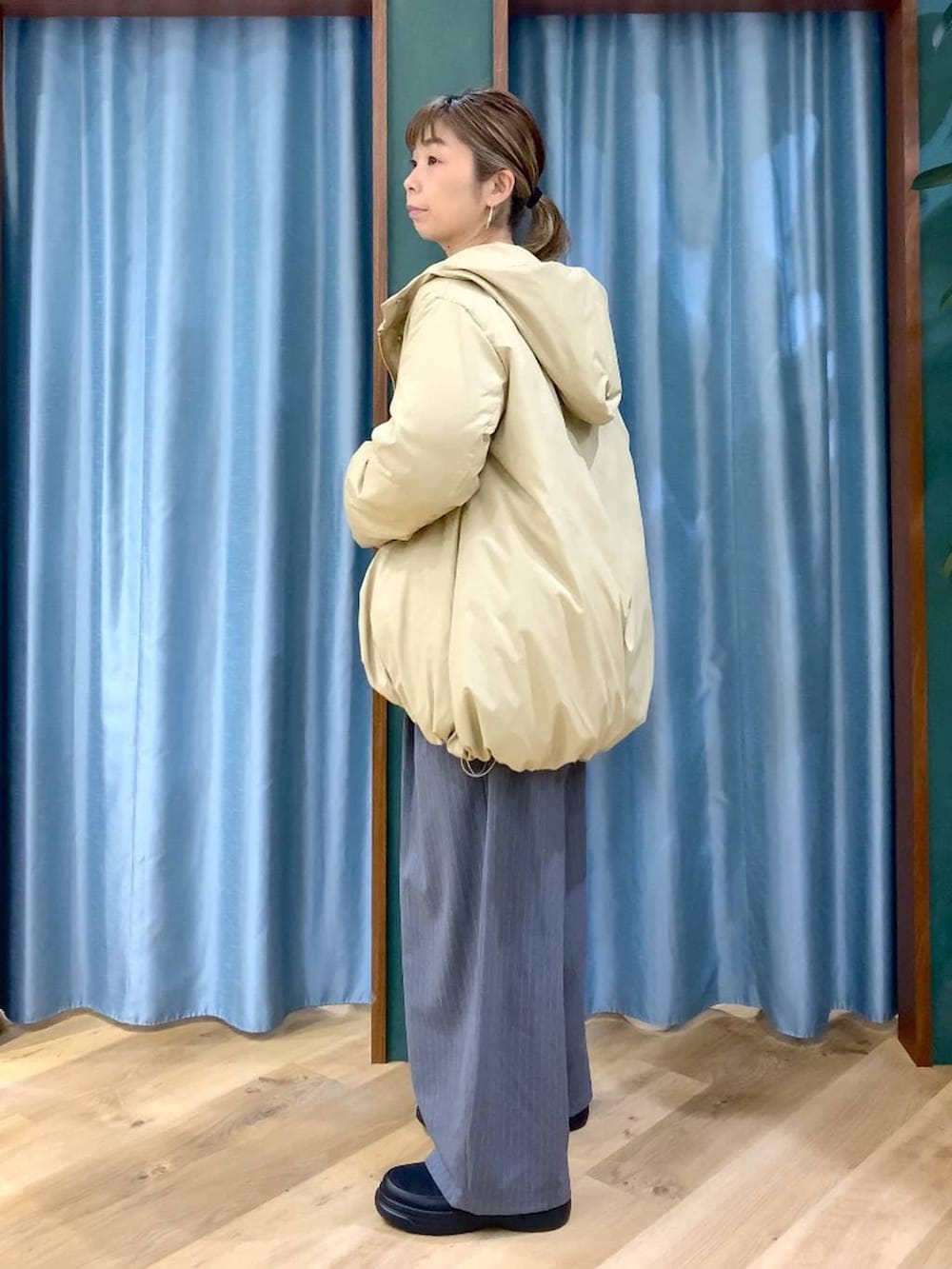 ベージュ系のダウンジャケット/コート、ベージュ系のニット/セーター、ブラック系のブーツを着用したレディースの冬コーディネートの3枚目の写真