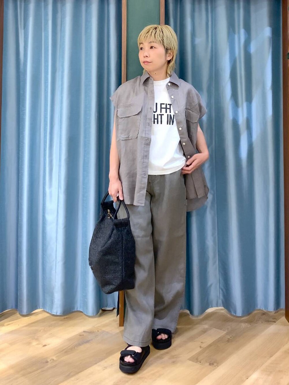 グレー系のその他パンツ、ホワイト系のTシャツ/カットソー、ブラック系のサンダルを着用したレディースの夏コーディネートの2枚目の写真