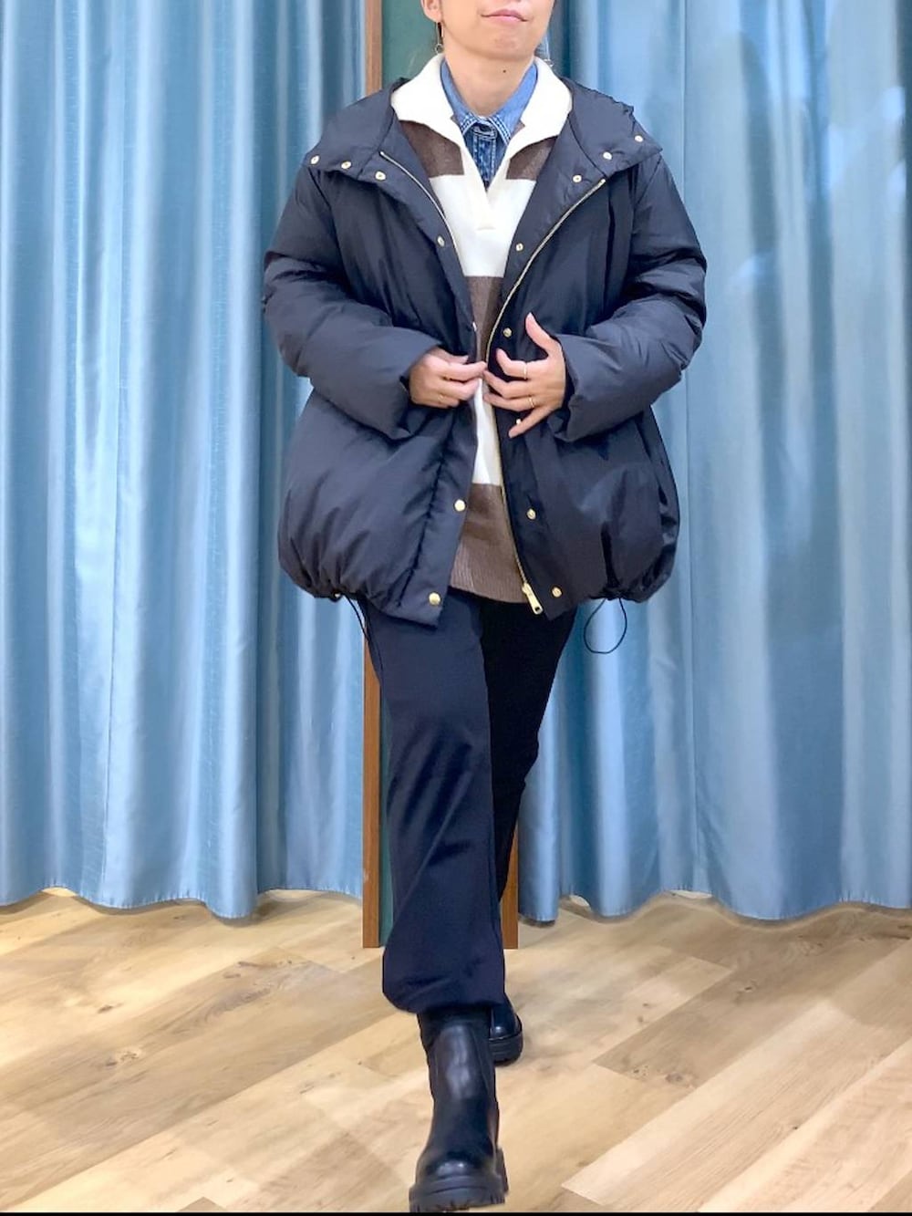 ブラック系のブーツ、ホワイト系のニット/セーター、ブルー系のシャツ/ブラウスを着用したレディースの冬コーディネートの8枚目の写真