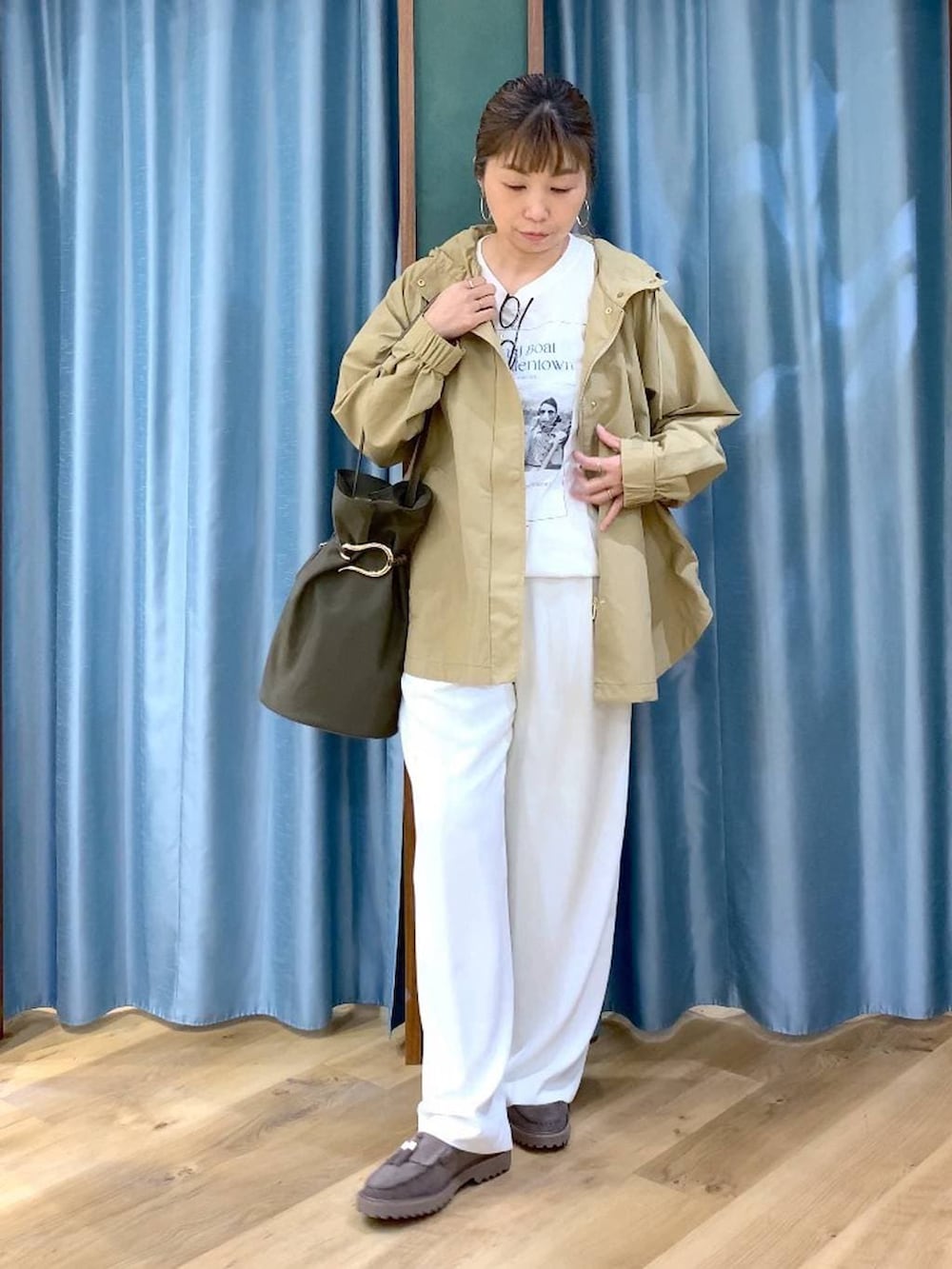 ホワイト系のその他パンツ、グレー系のローファー、ベージュ系のマウンテンパーカーを着用したレディースの春コーディネートの2枚目の写真