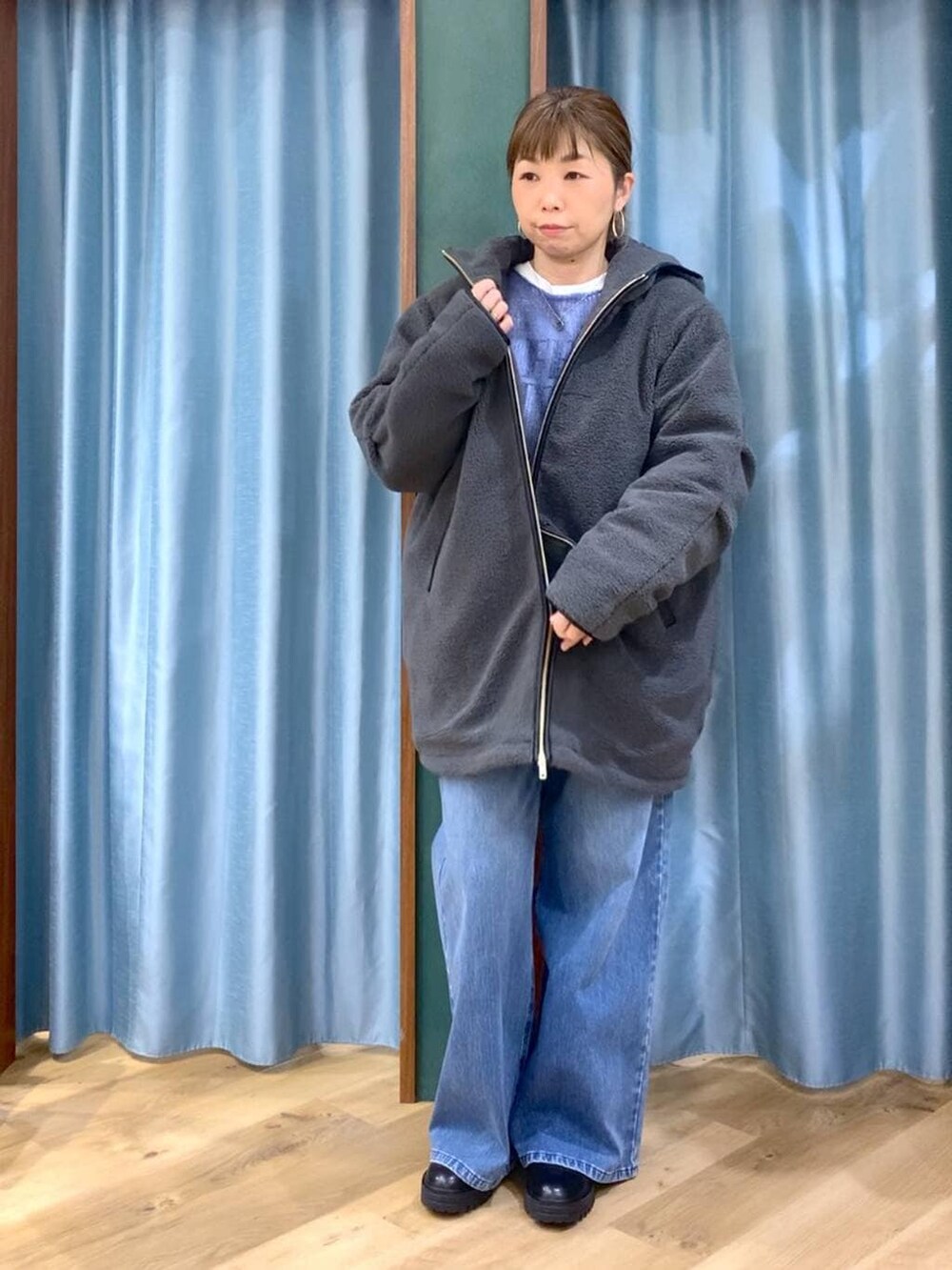 ブラック系のブーツ、ブルー系のデニムパンツ、ブルー系のニット/セーターを着用したレディースの冬コーディネートの7枚目の写真