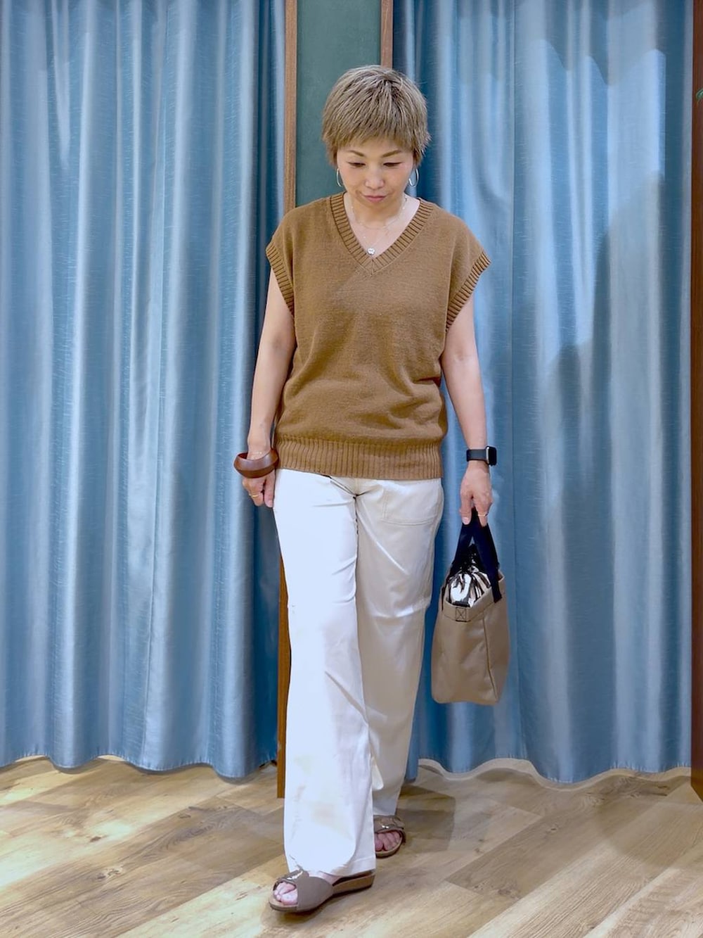ホワイト系のチノパンツ、ブラウン系のサンダル、ベージュ系のショルダーバッグを着用したレディースの夏コーディネートの2枚目の写真