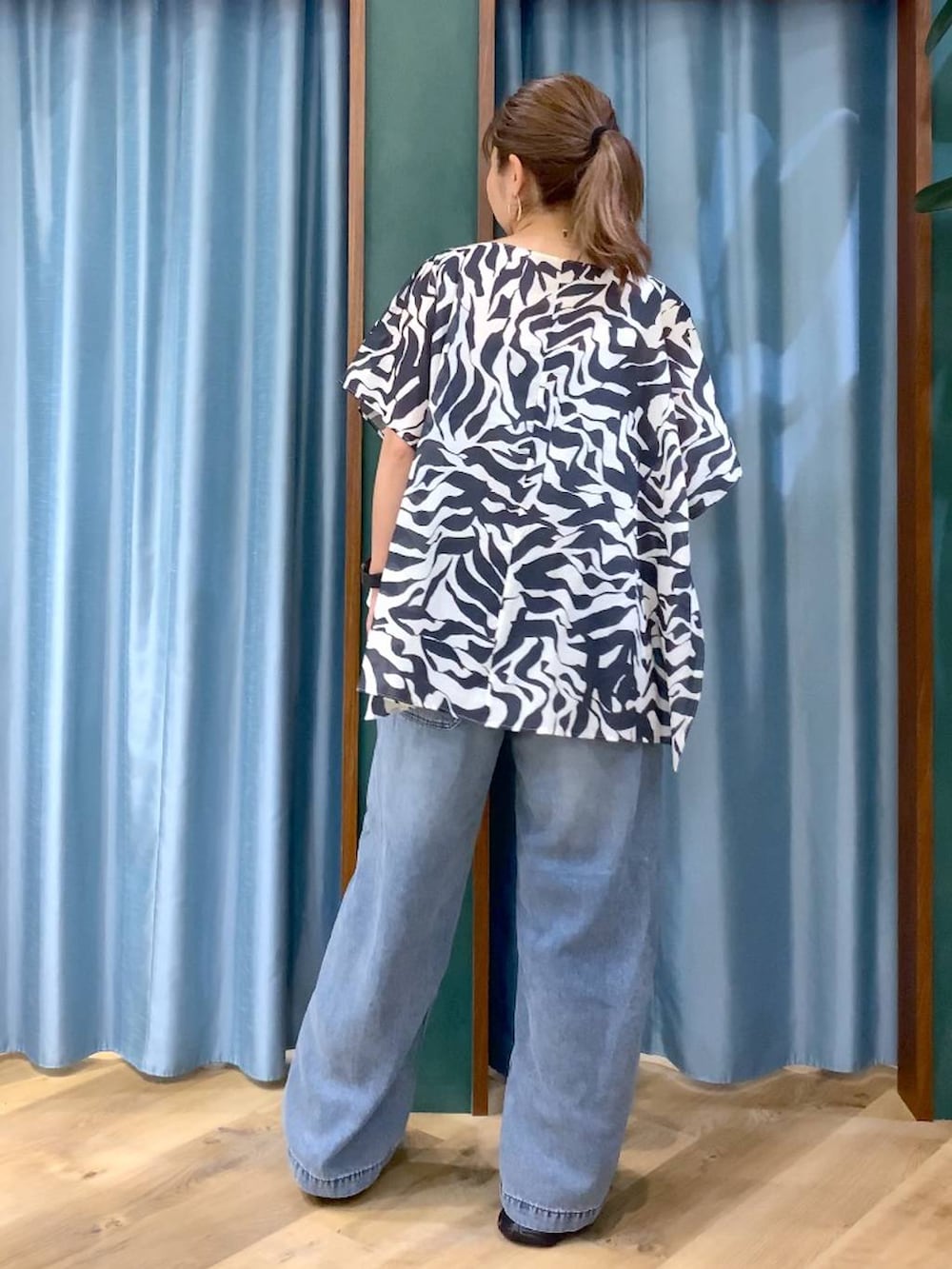 ブルー系のデニムパンツ、ブラック系のシャツ/ブラウス、ブラック系のサンダルを着用したレディースの春コーディネートの5枚目の写真