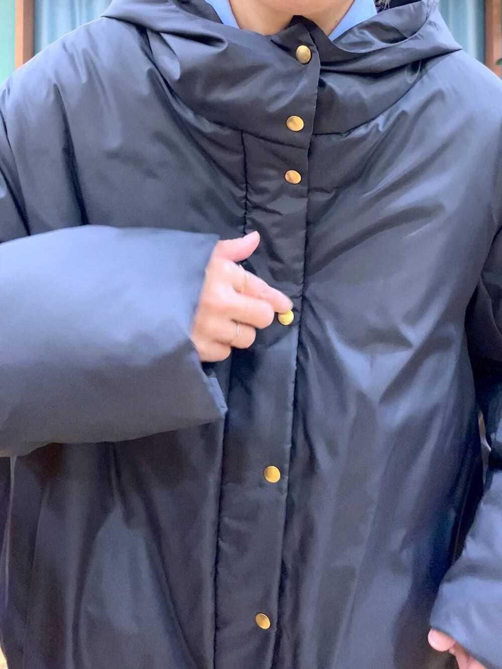 ブルー系のシャツ/ブラウス、ブラック系のダウンジャケット/コート、ブラウン系のローファーを着用したレディースの秋コーディネートの9枚目の写真