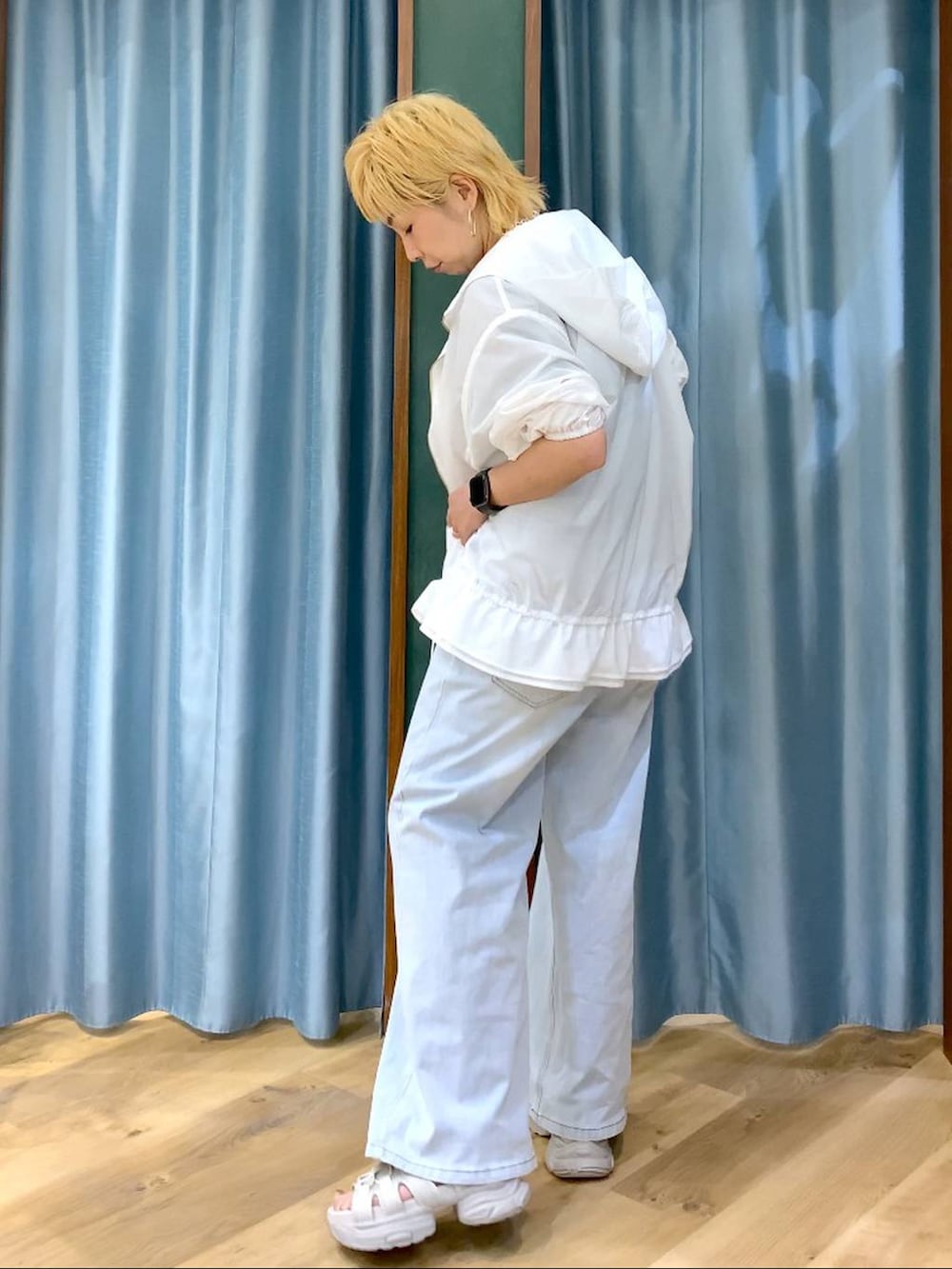 ブルー系のデニムパンツ、グレー系のサンダル、ホワイト系のブルゾンを着用したレディースの春コーディネートの5枚目の写真