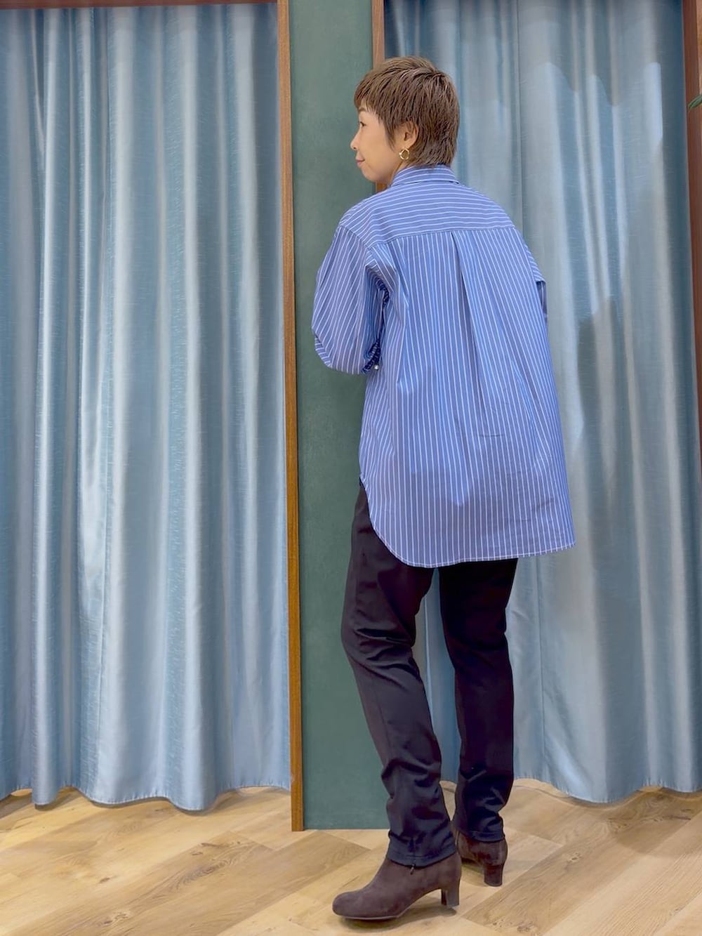 ブラック系のその他パンツ、ブラウン系のブーツ、ブルー系のシャツ/ブラウスを着用したレディースの秋コーディネートの5枚目の写真