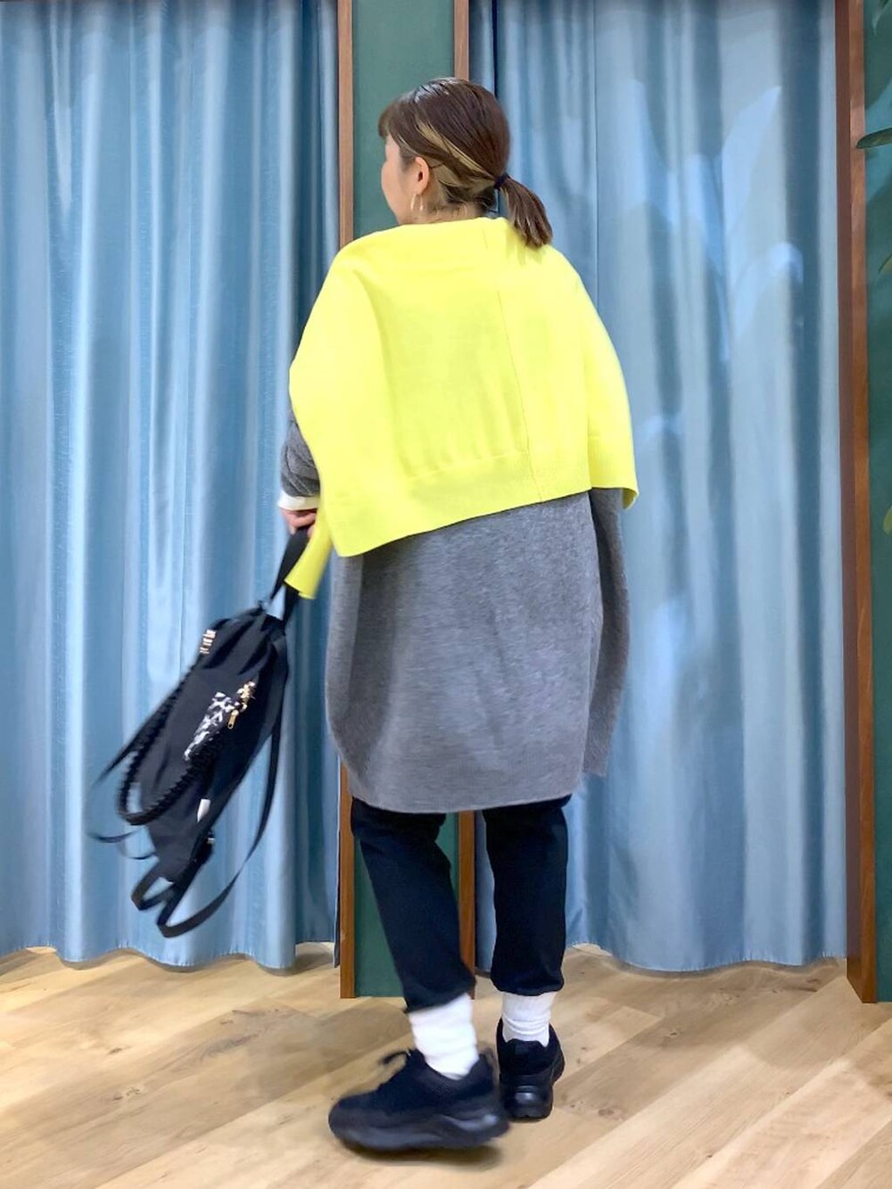 ブラック系のその他パンツ、ホワイト系のTシャツ/カットソー、イエロー系のニット/セーターを着用したレディースの秋コーディネートの2枚目の写真