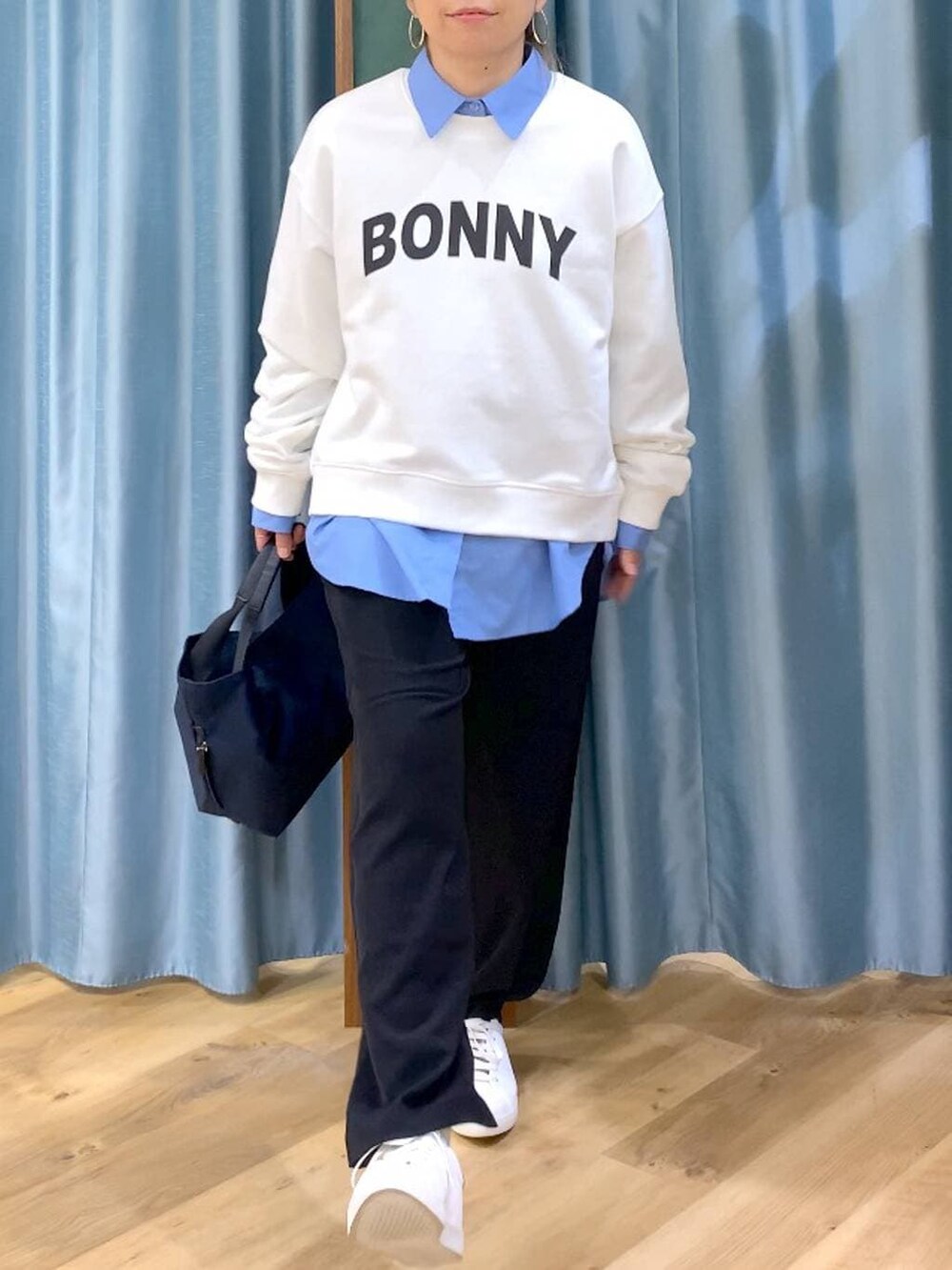 ブラック系のスラックス、ブルー系のトートバッグ、ブルー系のシャツ/ブラウスを着用したレディースの冬コーディネートの5枚目の写真