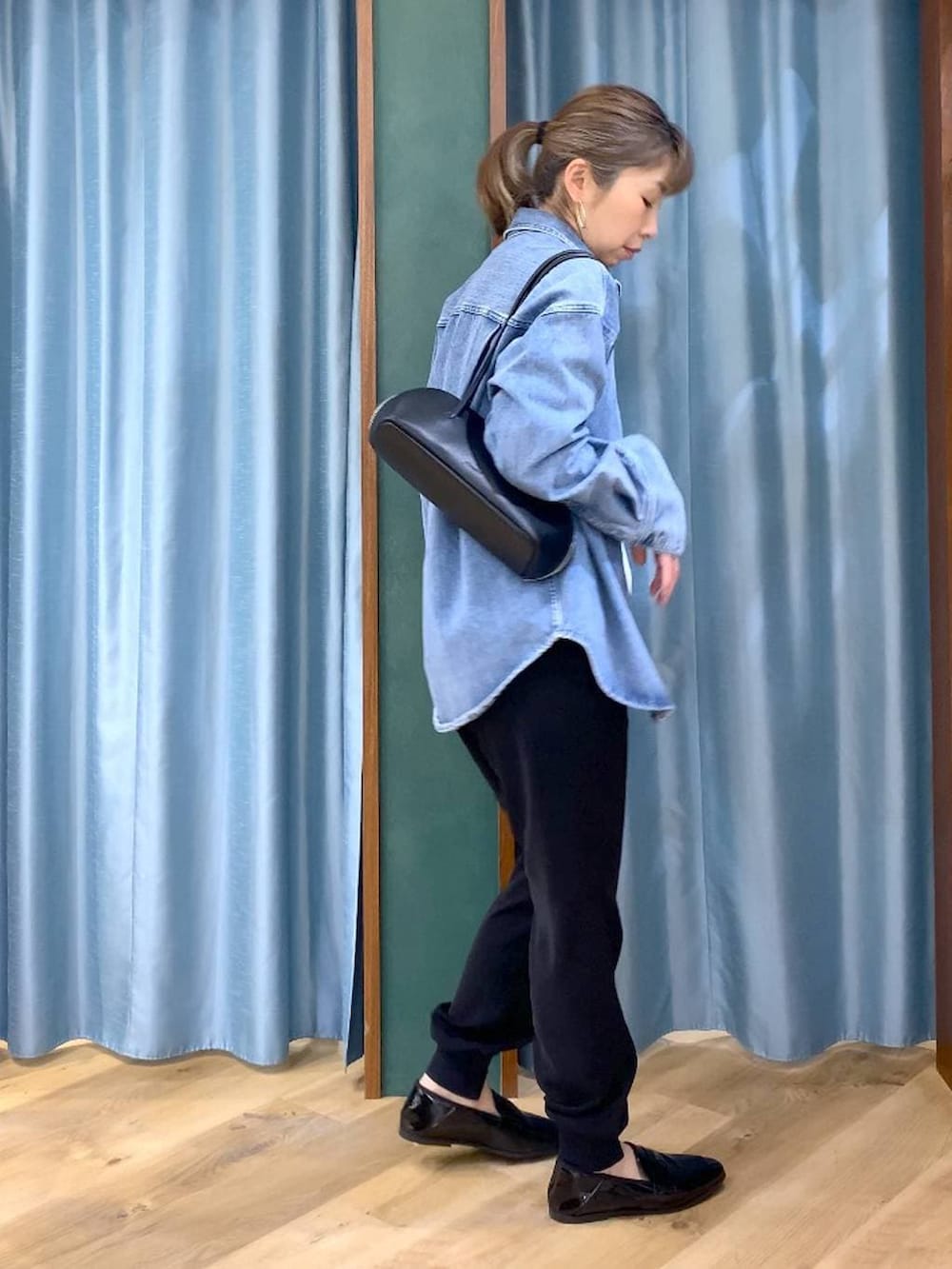 ブルー系のシャツ/ブラウス、ホワイト系のTシャツ/カットソー、ブラック系のハンドバッグを着用したレディースの春コーディネートの5枚目の写真