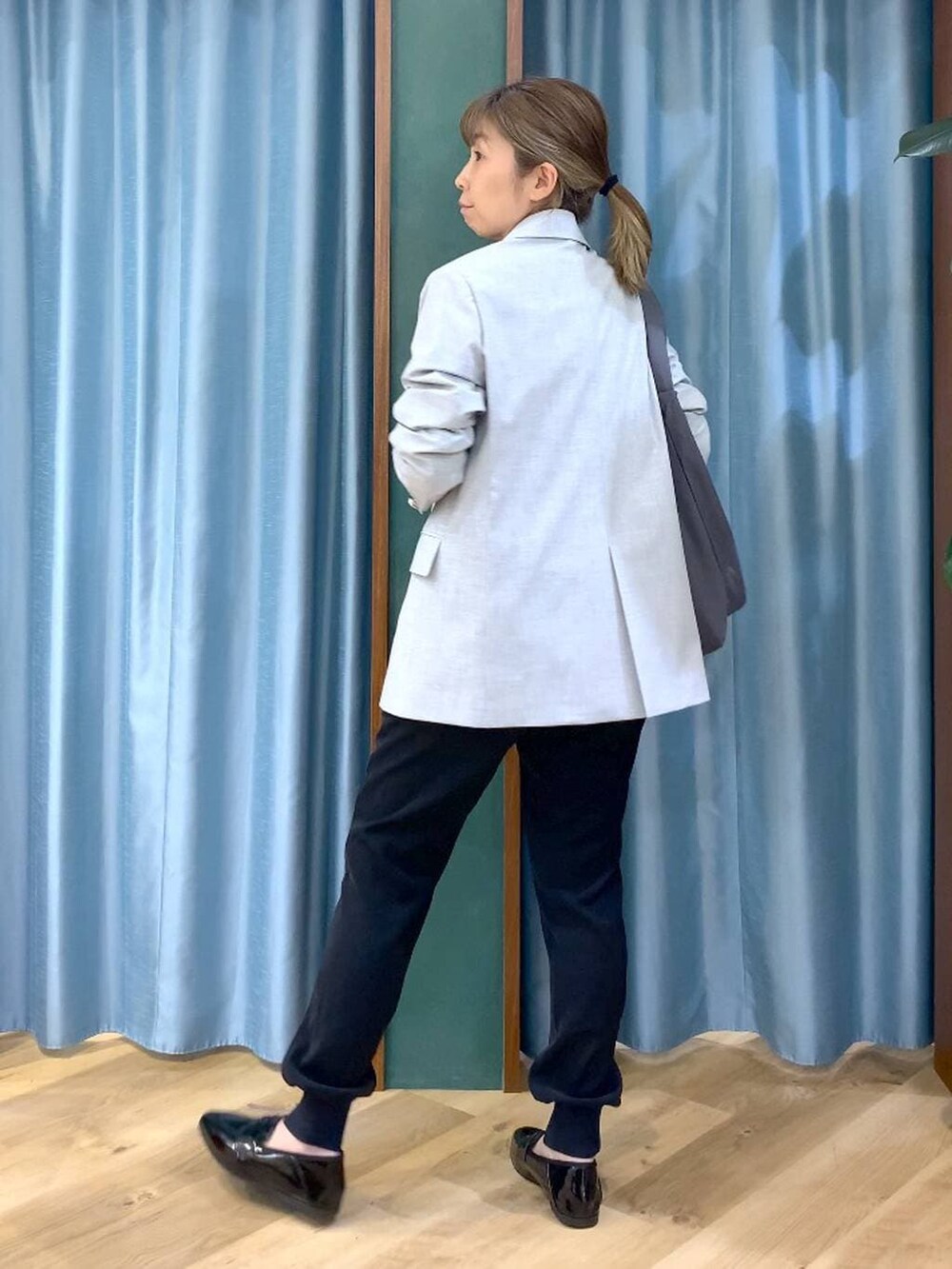 グレー系のショルダーバッグ、ホワイト系のTシャツ/カットソー、グレー系のテーラードジャケットを着用したレディースの冬コーディネートの5枚目の写真