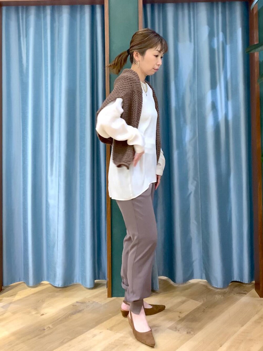 ブラウン系のニット/セーター、グリーン系のその他パンツ、ホワイト系のシャツ/ブラウスを着用したレディースの冬コーディネートの6枚目の写真