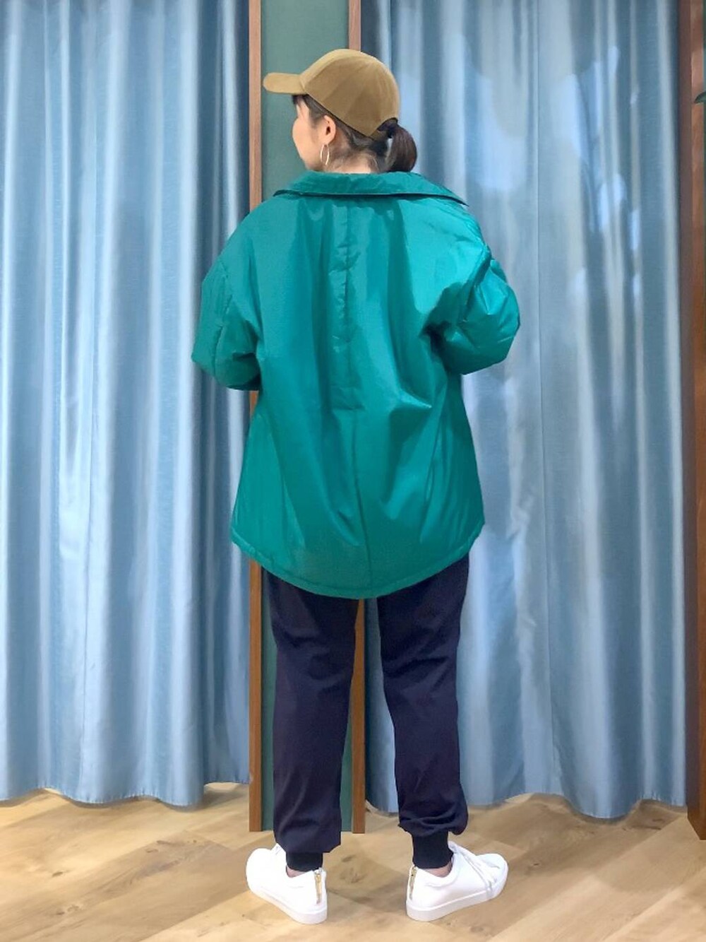 グリーン系のブルゾン、ブルー系のその他パンツ、ブラウン系のバックパック/リュックを着用したレディースの秋コーディネートの6枚目の写真