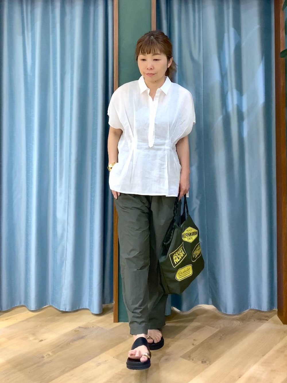 グリーン系のその他パンツ、ホワイト系のシャツ/ブラウス、ブラック系のサンダルを着用したレディースの春コーディネートの3枚目の写真