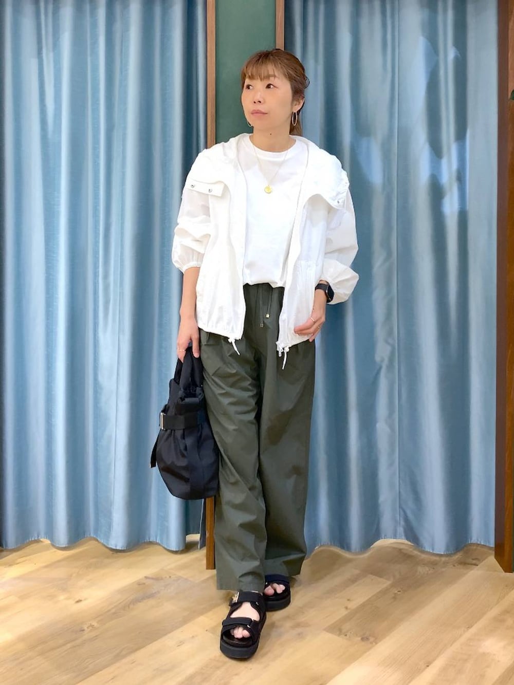 ホワイト系のTシャツ/カットソー、グリーン系のその他パンツ、ホワイト系のブルゾンを着用したレディースの春コーディネートの2枚目の写真