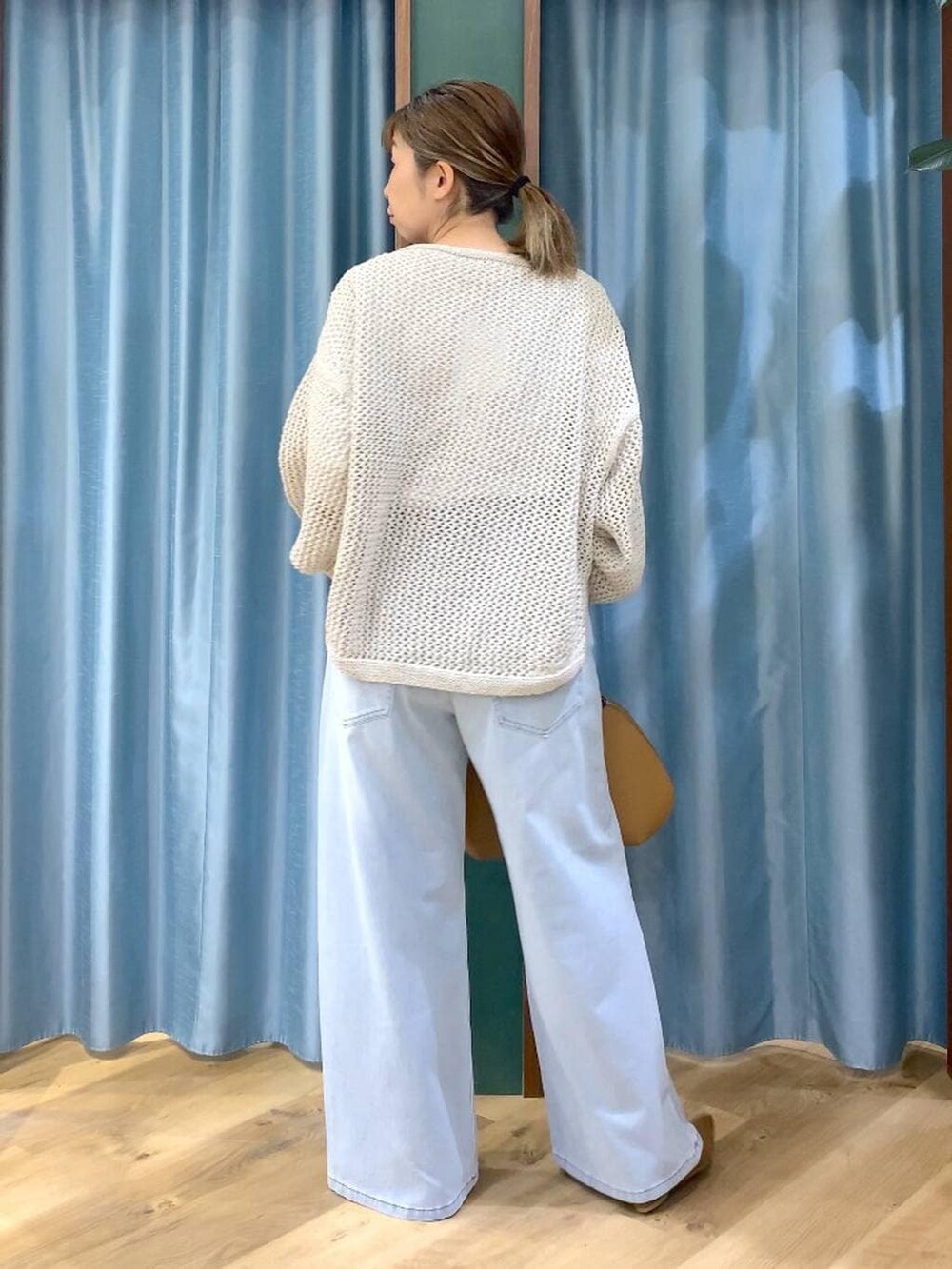 ベージュ系のニット/セーター、ブラウン系のトートバッグ、ホワイト系のTシャツ/カットソーを着用したレディースの冬コーディネートの7枚目の写真