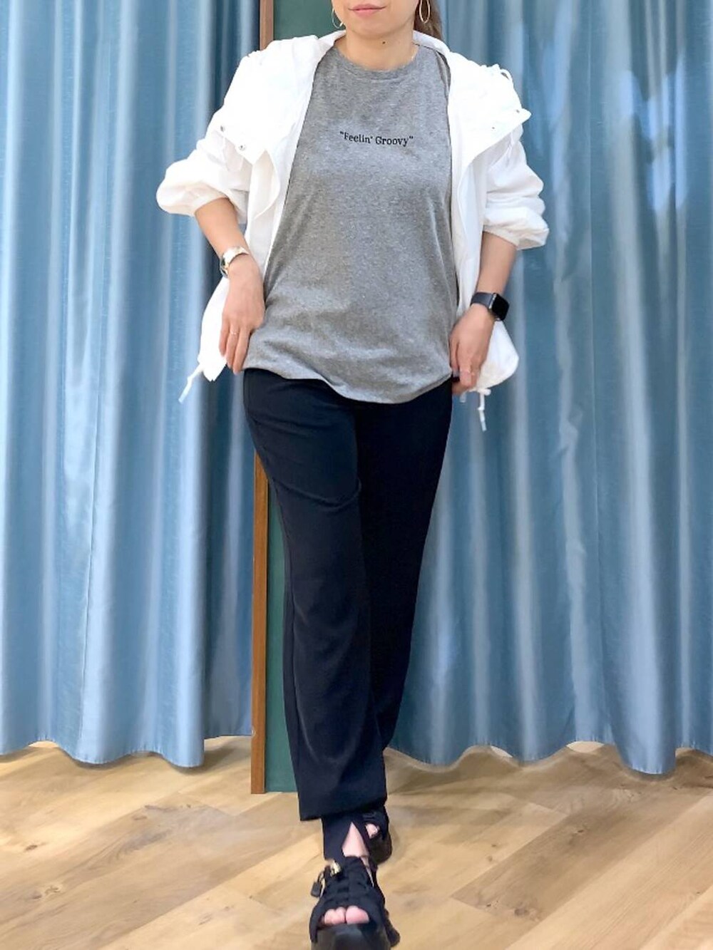 ホワイト系のブルゾン、グレー系のTシャツ/カットソー、ブラック系のサンダルを着用したレディースの春コーディネートの5枚目の写真
