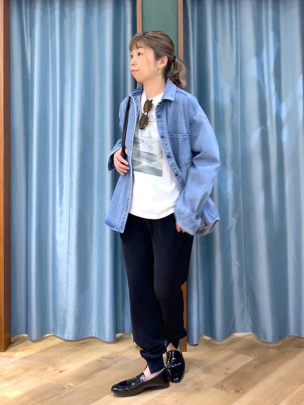 ブルー系のシャツ/ブラウス、ホワイト系のTシャツ/カットソー、ブラック系のハンドバッグを着用したレディースの春コーディネートの3枚目の写真