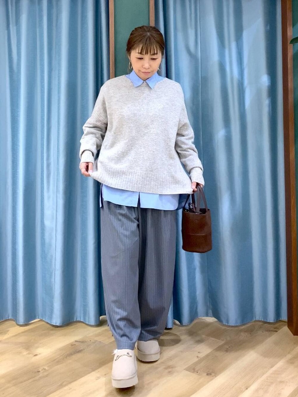 ブルー系のシャツ/ブラウス、ベージュ系のスリッポン、ベージュ系のニット/セーターを着用したレディースの冬コーディネートの8枚目の写真