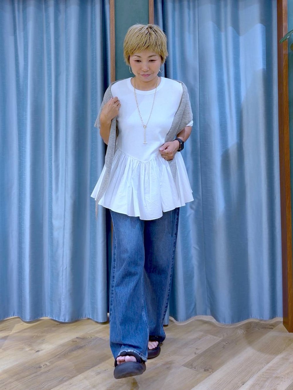 ホワイト系のTシャツ/カットソー、ブラック系のサンダル、ブルー系のデニムパンツを着用したレディースの夏コーディネートの2枚目の写真