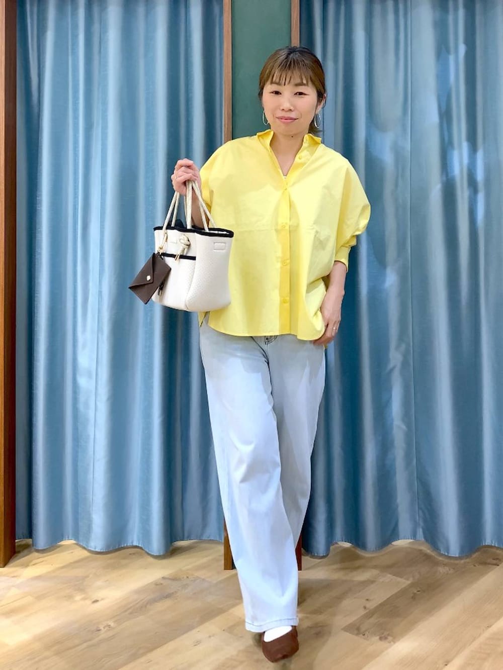 ブラウン系のパンプス、ブルー系のデニムパンツ、イエロー系のシャツ/ブラウスを着用したレディースの春コーディネートの2枚目の写真