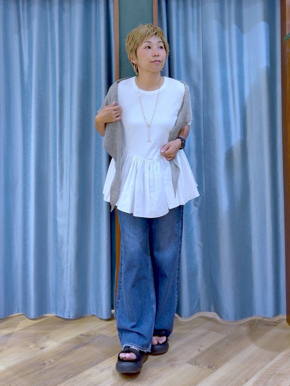 ホワイト系のTシャツ/カットソー、ブラック系のサンダル、ブルー系のデニムパンツを着用したレディースの夏コーディネートの3枚目の写真