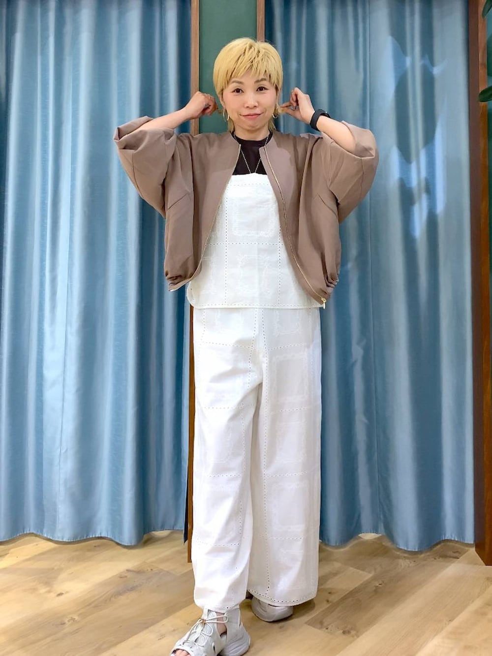 ブラウン系のTシャツ/カットソー、イエロー系のブルゾン、グレー系のサンダルを着用したレディースの春コーディネートの2枚目の写真