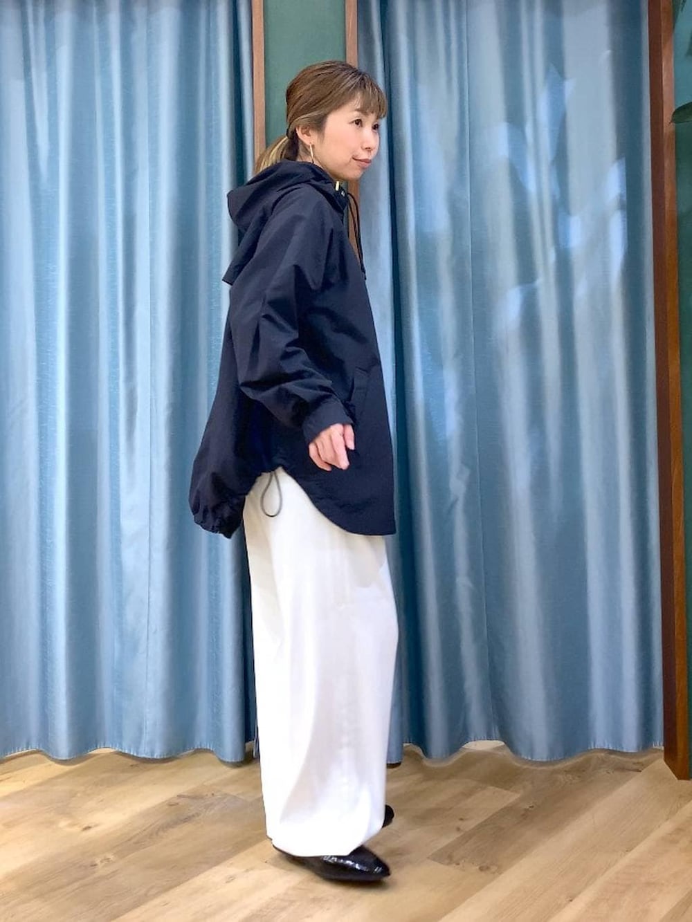 ホワイト系のスラックス、ベージュ系のTシャツ/カットソー、ブラック系のローファーを着用したレディースの春コーディネートの3枚目の写真