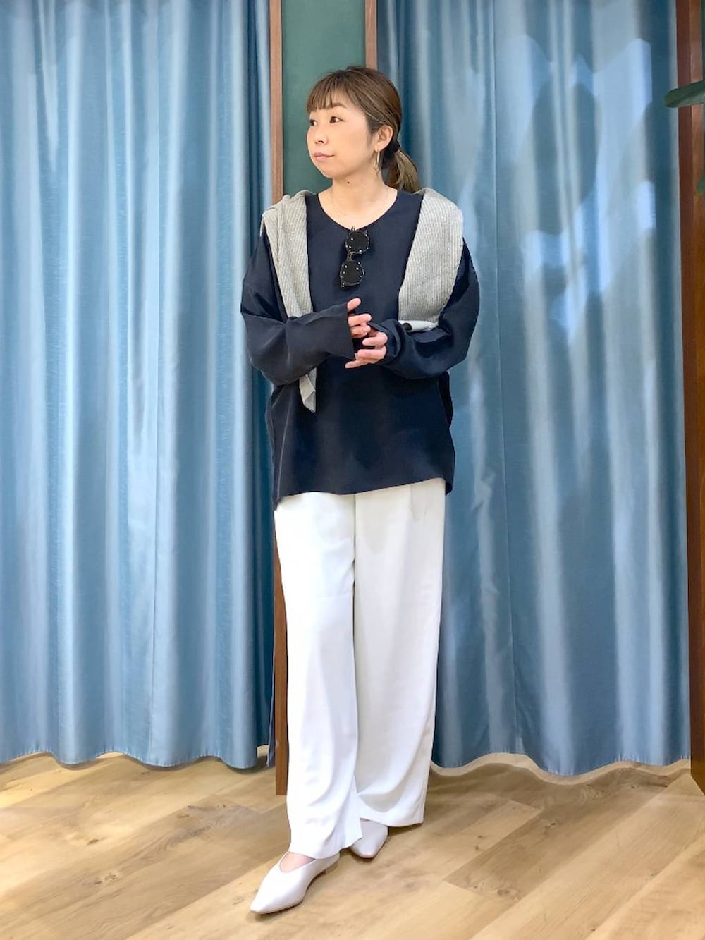 ホワイト系のスラックス、ベージュ系のカーディガン/ボレロ、ホワイト系のパンプスを着用したレディースの冬コーディネートの4枚目の写真