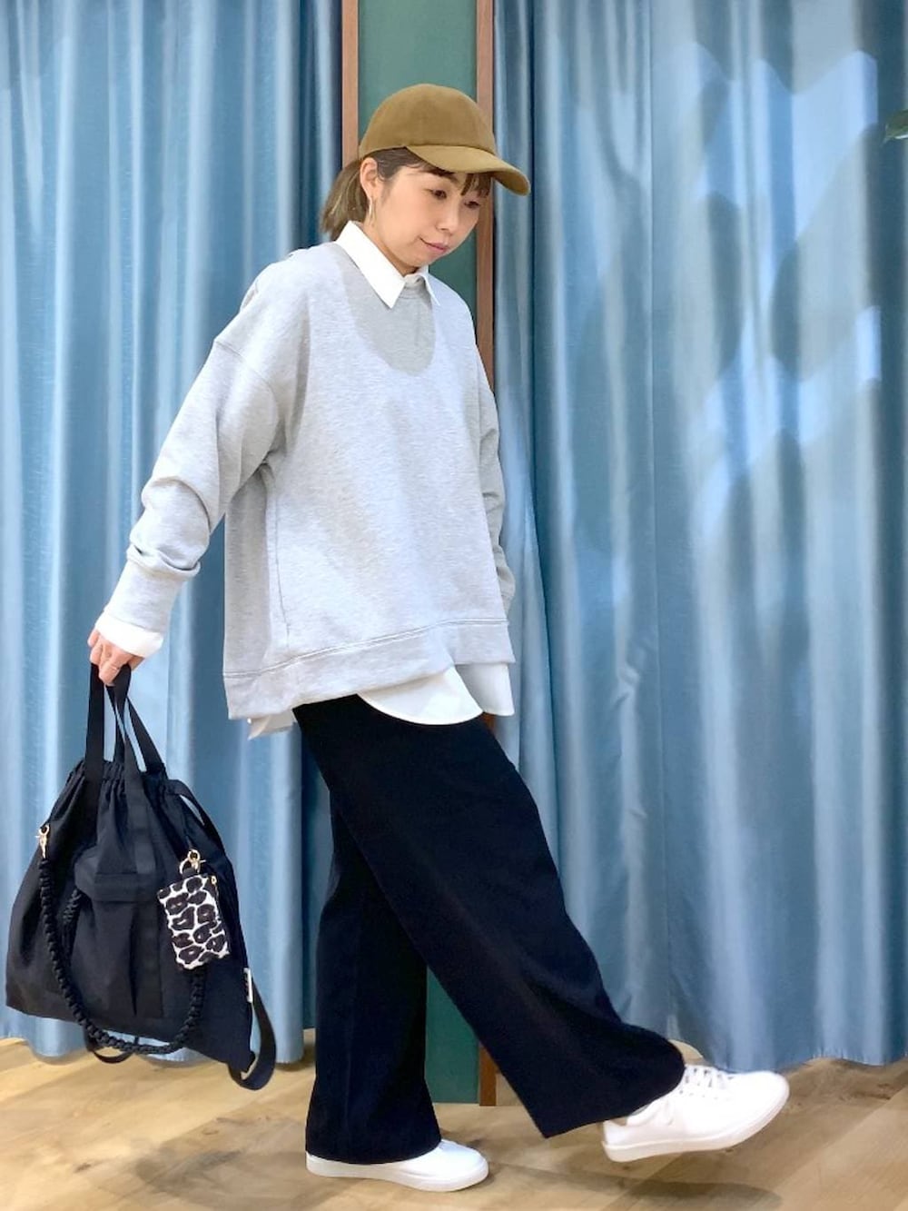 ブラック系のスラックス、グレー系のスウェット、ブラック系のバックパック/リュックを着用したレディースの冬コーディネートの3枚目の写真