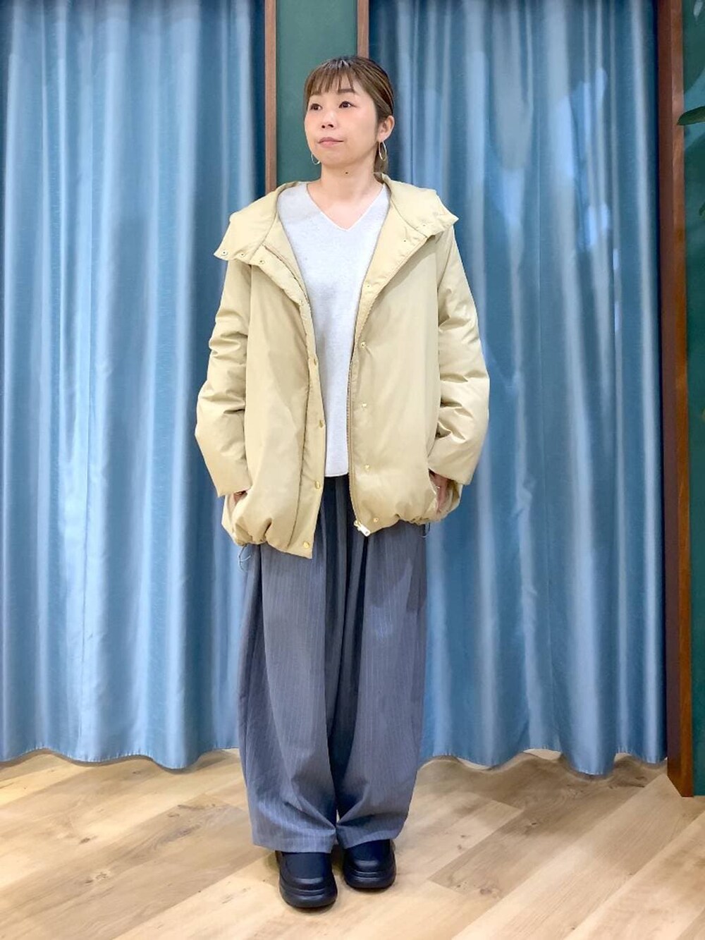 ベージュ系のダウンジャケット/コート、ベージュ系のニット/セーター、ブラック系のブーツを着用したレディースの冬コーディネートの2枚目の写真