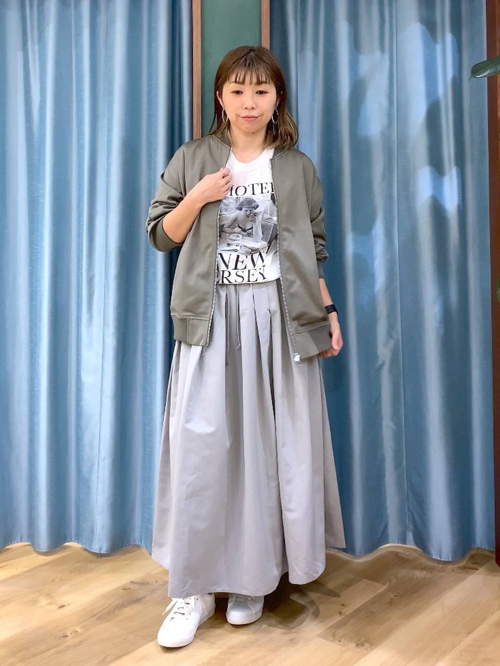 グレー系のスカート、グリーン系のMA-1、ホワイト系のTシャツ/カットソーを着用したレディースの冬コーディネートの6枚目の写真