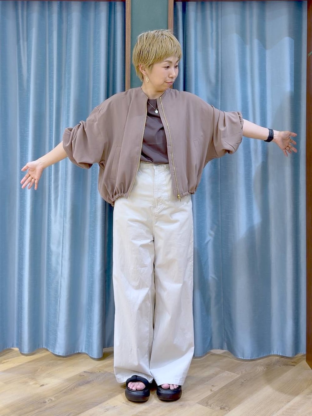 イエロー系のブルゾン、ベージュ系のその他パンツ、ブラック系のサンダルを着用したレディースの夏コーディネートの5枚目の写真
