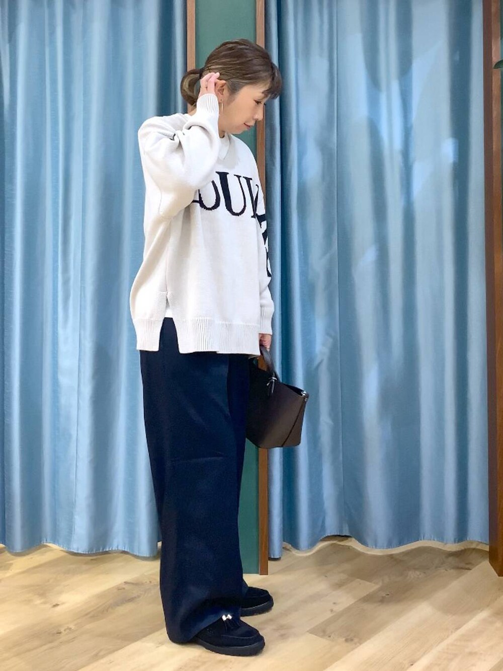 ベージュ系のニット/セーター、ブラック系のローファー、ホワイト系のTシャツ/カットソーを着用したレディースの秋コーディネートの3枚目の写真