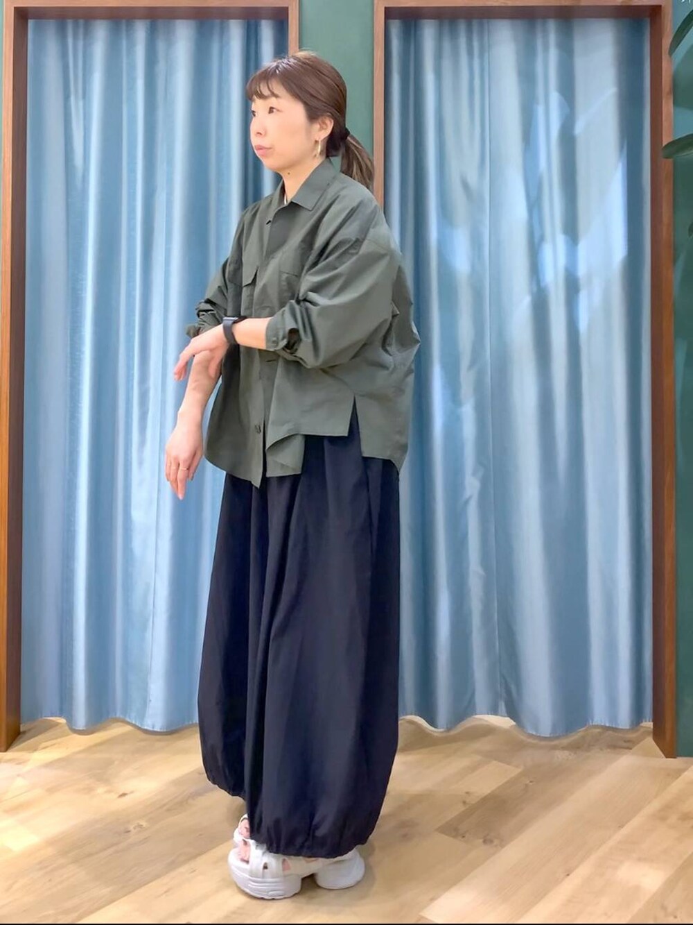 ホワイト系のTシャツ/カットソー、グリーン系のシャツ/ブラウス、グレー系のサンダルを着用したレディースの春コーディネートの4枚目の写真