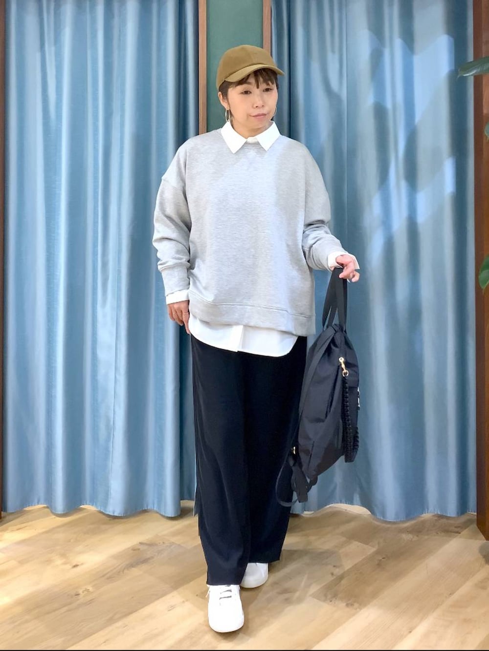 ブラック系のスラックス、グレー系のスウェット、ブラック系のバックパック/リュックを着用したレディースの冬コーディネートの2枚目の写真