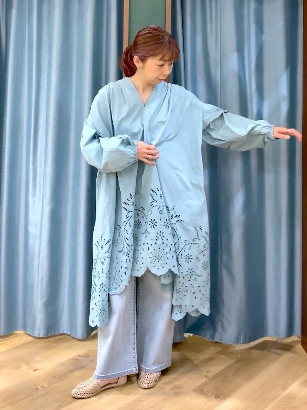 ブルー系のデニムパンツ、ベージュ系のスリッポン、グリーン系のワンピースを着用したレディースの春コーディネートの4枚目の写真