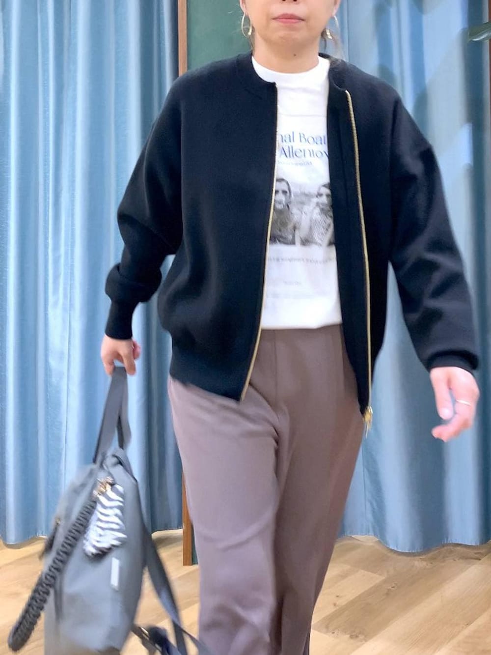 グリーン系のスラックス、ブラック系のカーディガン/ボレロ、グレー系のバックパック/リュックを着用したレディースの冬コーディネートの9枚目の写真