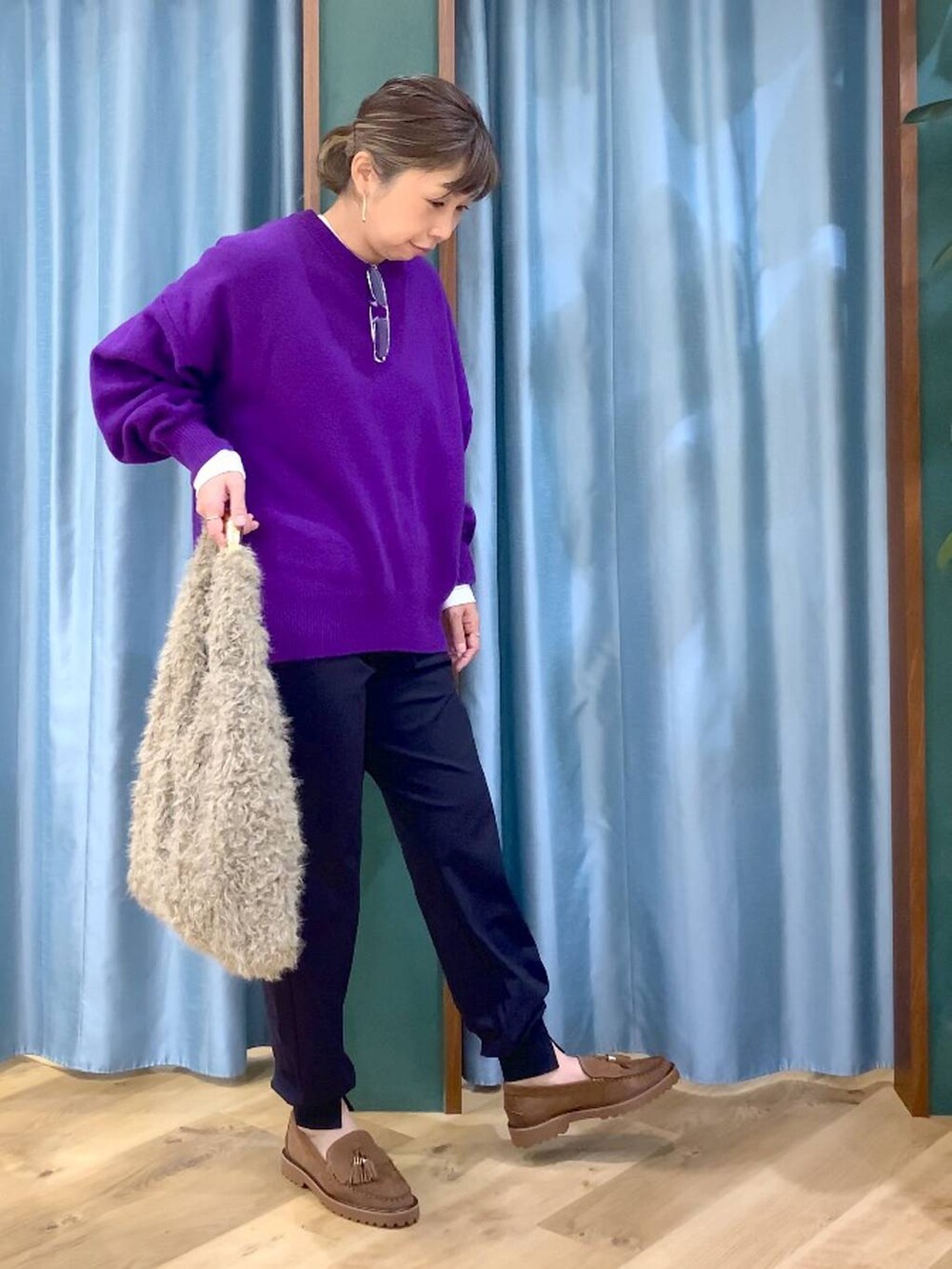 パープル系のニット/セーター、ベージュ系のハンドバッグ、ブルー系のその他パンツを着用したレディースの秋コーディネートの4枚目の写真