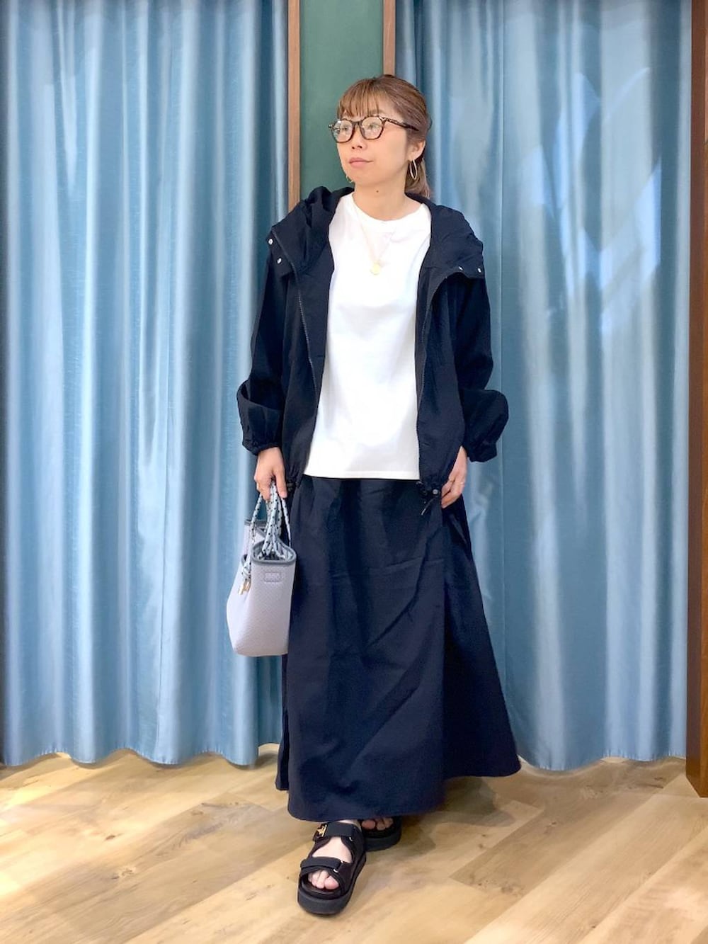 ホワイト系のTシャツ/カットソー、ブラック系のスカート、ブラック系のブルゾンを着用したレディースの春コーディネートの2枚目の写真