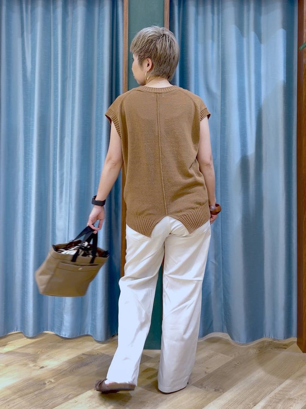 ホワイト系のチノパンツ、ブラウン系のサンダル、ベージュ系のショルダーバッグを着用したレディースの夏コーディネートの7枚目の写真