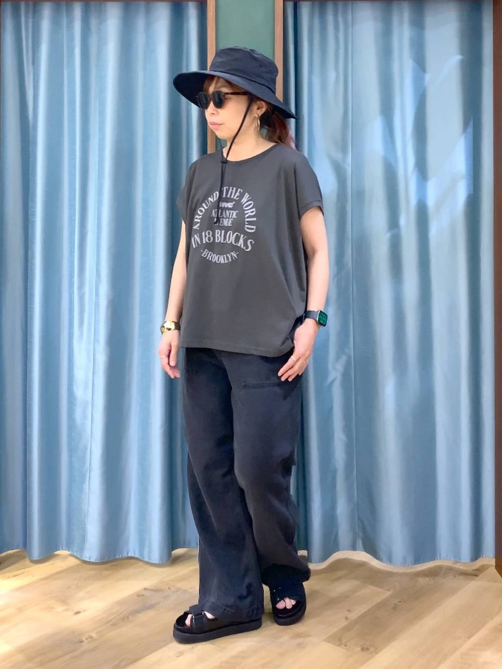 ブラック系のTシャツ/カットソー、グレー系のデニムパンツ、ブラック系のサンダルを着用したレディースの春コーディネートの5枚目の写真