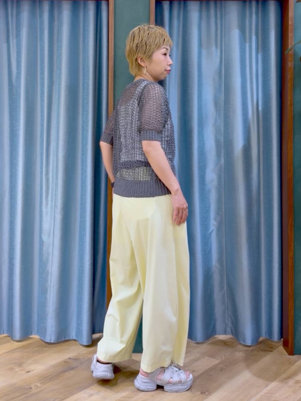 ホワイト系のタンクトップ、イエロー系のその他パンツ、グレー系のサンダルを着用したレディースの夏コーディネートの3枚目の写真