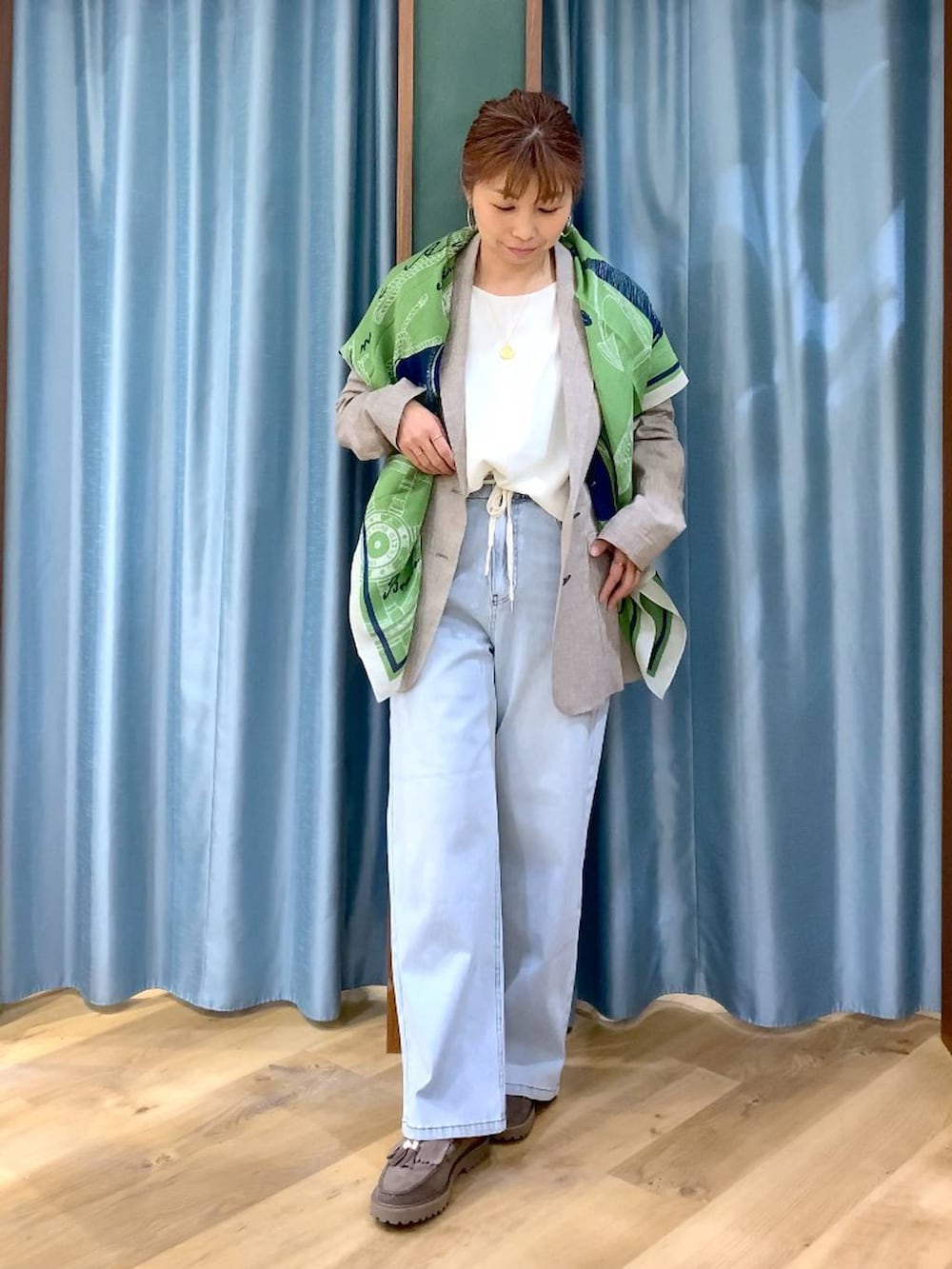 グレー系のローファー、ブルー系のデニムパンツ、ベージュ系のテーラードジャケットを着用したレディースの春コーディネートの4枚目の写真