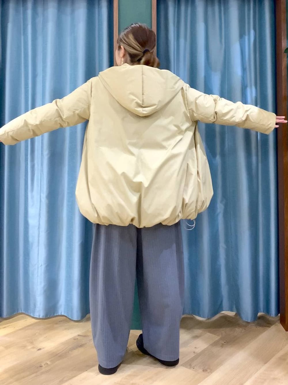 ベージュ系のダウンジャケット/コート、ベージュ系のニット/セーター、ブラック系のブーツを着用したレディースの冬コーディネートの5枚目の写真